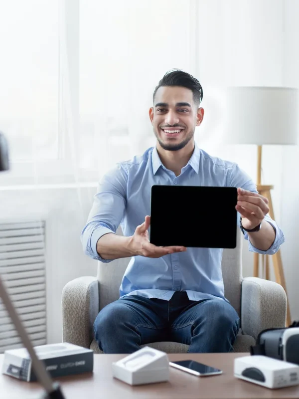 arab male influencer shooting video review of modern tablet computer on professional dslr camera at